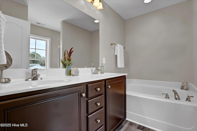 bathroom featuring hardwood / wood-style flooring, vanity, and a bathtub