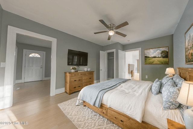 bedroom with ceiling fan, ensuite bath, a closet, and light wood-type flooring