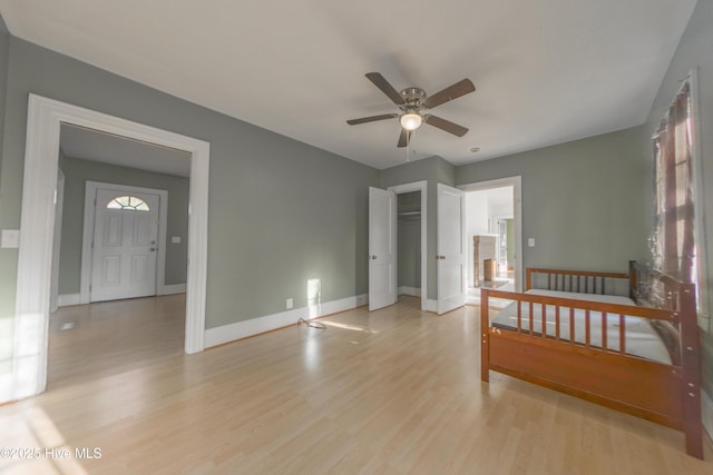 bedroom with ceiling fan, light hardwood / wood-style floors, and a closet