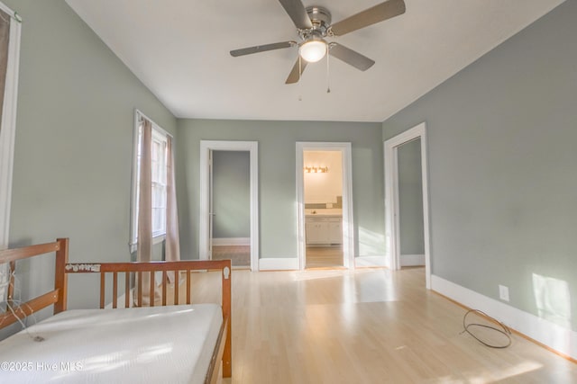 bedroom with connected bathroom, light hardwood / wood-style flooring, and ceiling fan