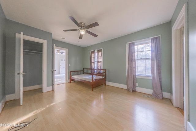 unfurnished bedroom with ceiling fan, a closet, and light hardwood / wood-style flooring