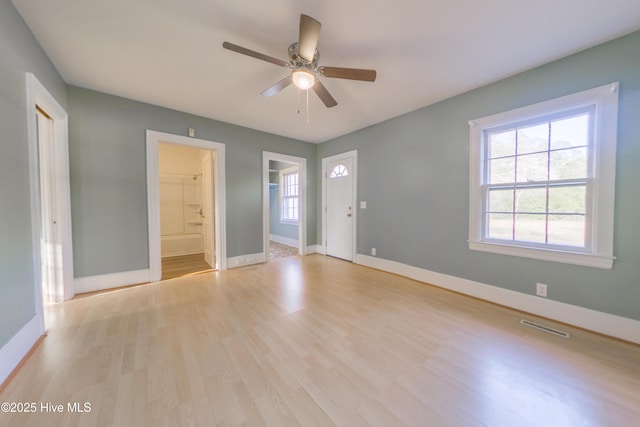 empty room featuring ceiling fan, plenty of natural light, and light hardwood / wood-style floors