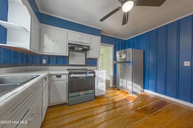 kitchen with crown molding, ceiling fan, stainless steel appliances, light hardwood / wood-style floors, and white cabinets