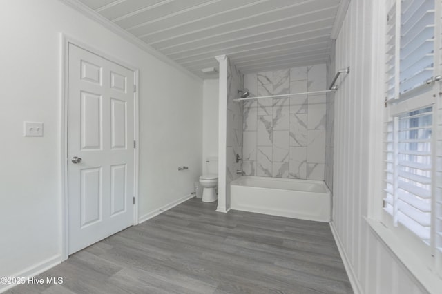 bathroom featuring tiled shower / bath combo, wood-type flooring, and toilet