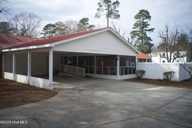 back of property with a carport and a sunroom