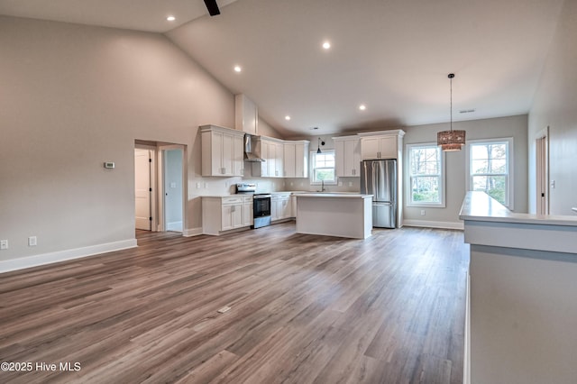 kitchen featuring white cabinets, stainless steel appliances, light countertops, light wood-style floors, and baseboards