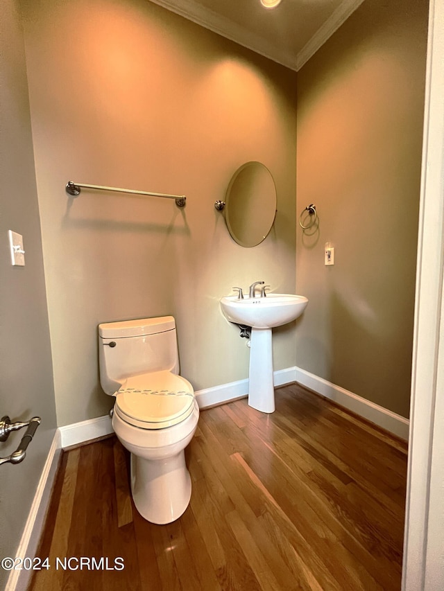 bathroom featuring crown molding, wood-type flooring, and toilet