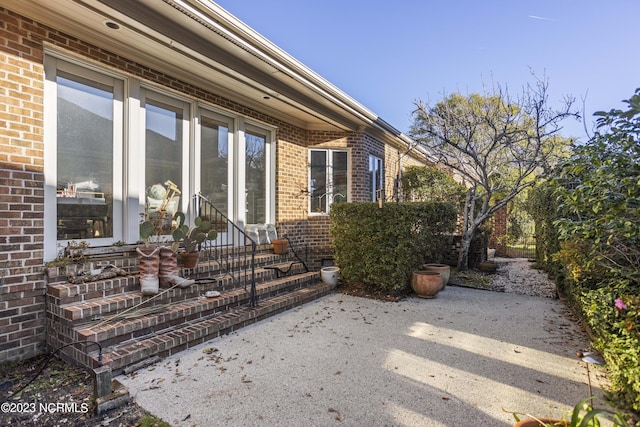 view of exterior entry with a patio