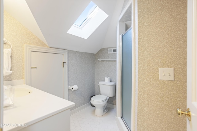 bathroom featuring toilet, vanity, vaulted ceiling with skylight, and a shower with door