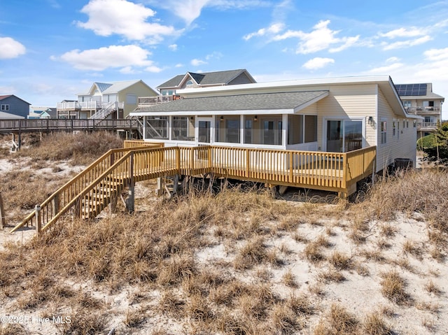 rear view of house with a deck and a sunroom