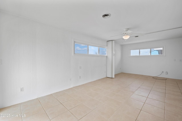 tiled spare room featuring ceiling fan