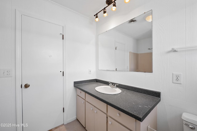 bathroom featuring vanity, ornamental molding, and toilet