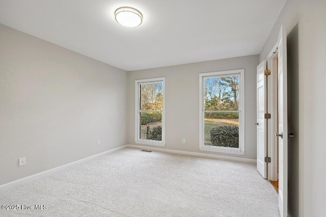 spare room featuring light carpet