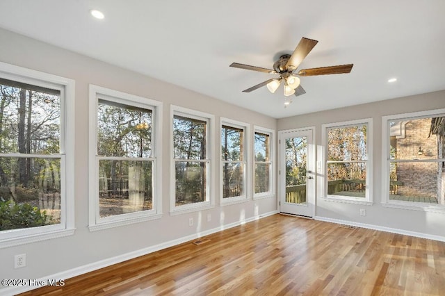 unfurnished sunroom featuring ceiling fan