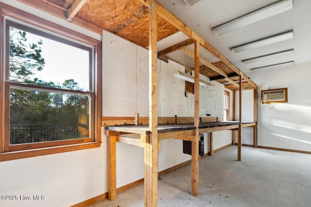 basement featuring a wall mounted air conditioner and a workshop area