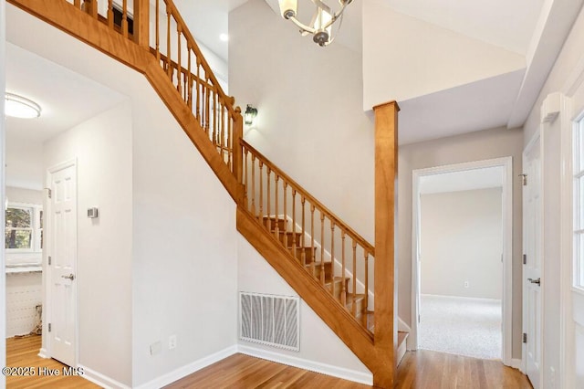 staircase featuring hardwood / wood-style floors and a high ceiling