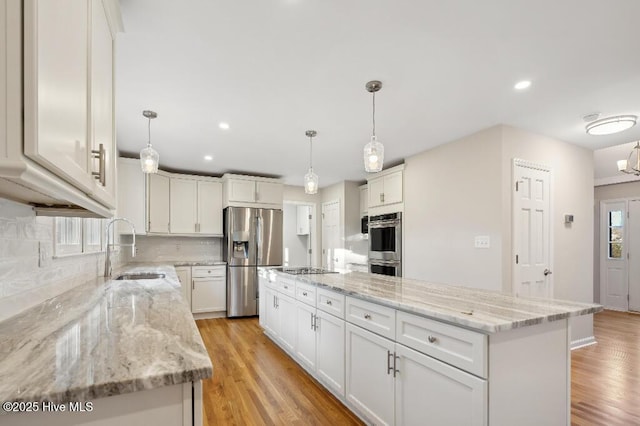 kitchen with stainless steel appliances, white cabinetry, hanging light fixtures, and a center island