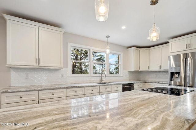 kitchen with appliances with stainless steel finishes, decorative light fixtures, white cabinetry, sink, and light stone counters