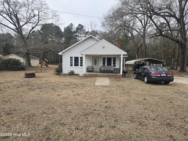 view of front of house featuring a carport, a playground, covered porch, and a front lawn