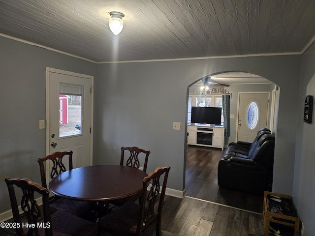 dining space with crown molding, dark wood-type flooring, and wooden ceiling