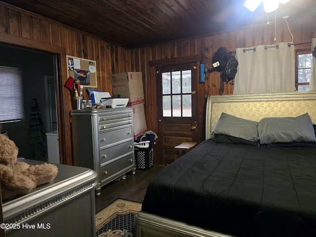 bedroom with dark hardwood / wood-style flooring, wood ceiling, and wood walls