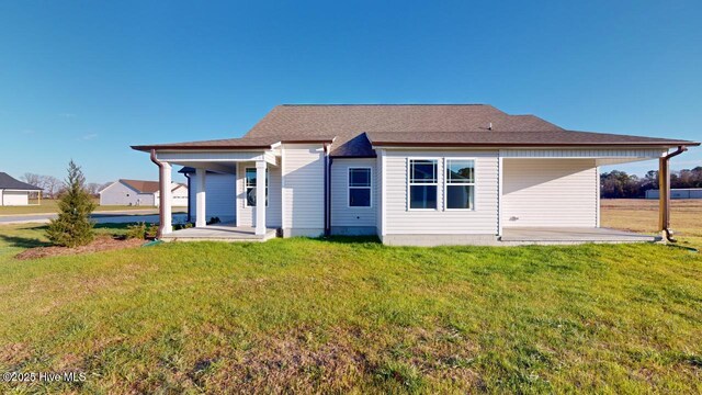 back of property with a yard and covered porch