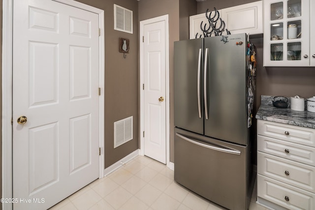 kitchen with stainless steel refrigerator and white cabinets