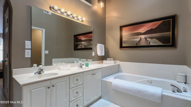 bathroom featuring vanity and tiled tub