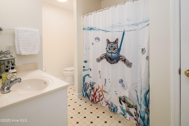 bathroom featuring vanity, curtained shower, and toilet