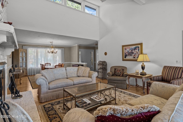 living room with plenty of natural light, a chandelier, crown molding, and wood finished floors