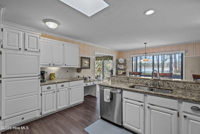 kitchen featuring stone countertops, white cabinets, decorative light fixtures, stainless steel dishwasher, and a sink