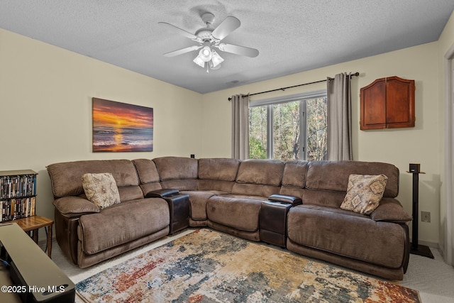 carpeted living room with a ceiling fan and a textured ceiling