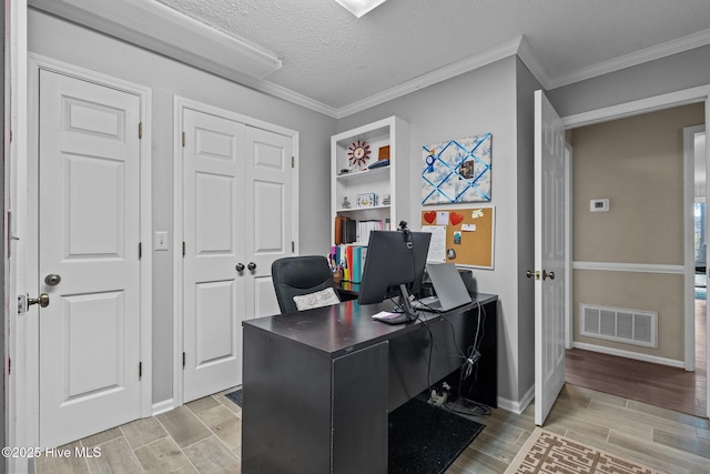 office featuring a textured ceiling, ornamental molding, wood finish floors, and visible vents