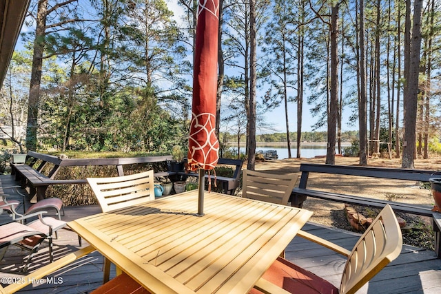 deck featuring outdoor dining area and a water view