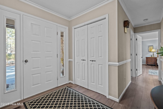 entrance foyer with crown molding, a textured ceiling, baseboards, and wood finished floors