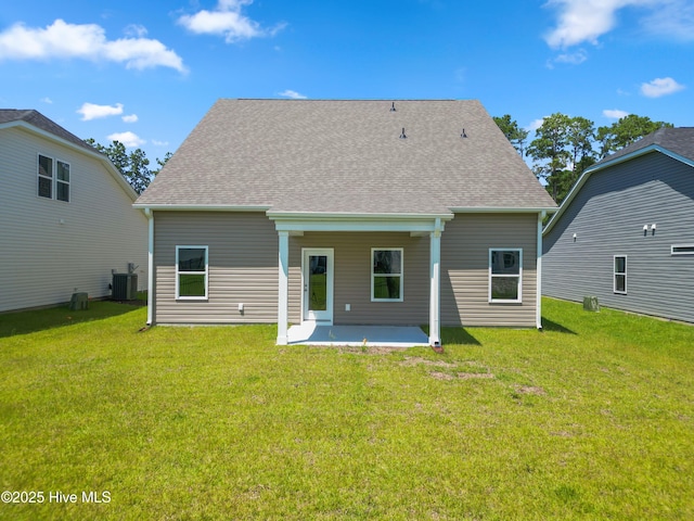 rear view of property with a patio, a yard, and central air condition unit