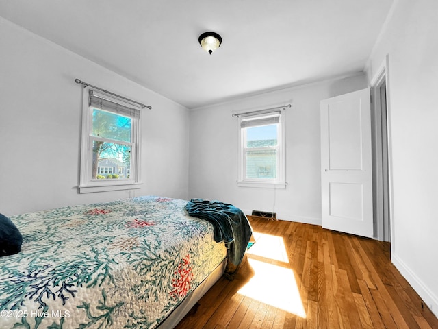 bedroom with baseboards and hardwood / wood-style floors