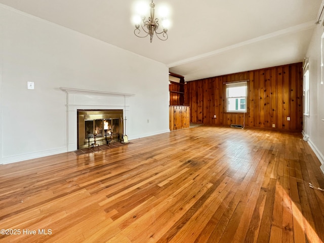 unfurnished living room with baseboards, a fireplace with flush hearth, light wood-style flooring, and an inviting chandelier