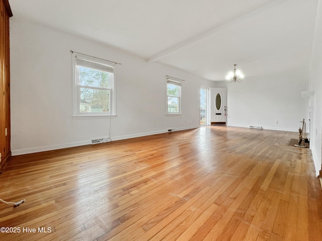 unfurnished living room featuring light wood-type flooring, baseboards, visible vents, and a notable chandelier