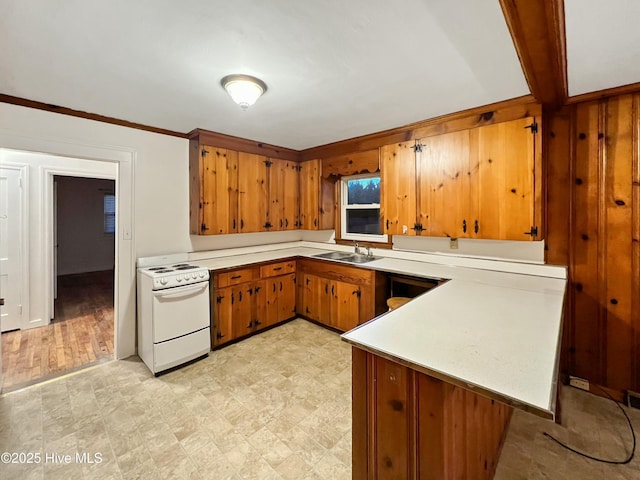 kitchen with brown cabinets, white electric stove, light countertops, a sink, and a peninsula