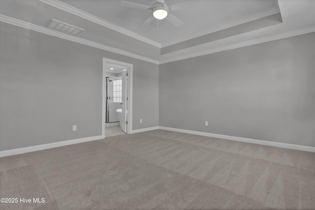 empty room with light carpet, ornamental molding, a raised ceiling, and ceiling fan