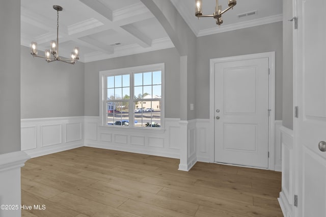 entryway featuring beamed ceiling, coffered ceiling, a chandelier, and light wood-type flooring