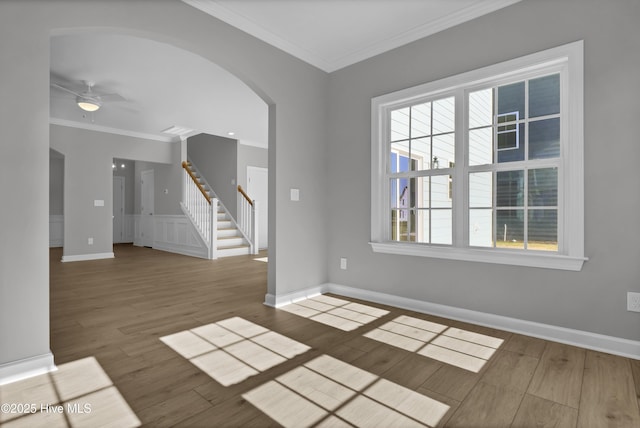 empty room with hardwood / wood-style floors, crown molding, and ceiling fan