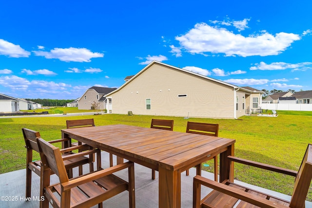 deck with a residential view, outdoor dining area, and a lawn