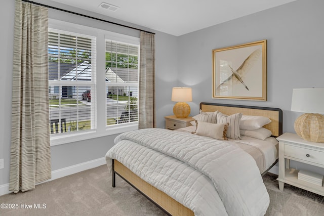 carpeted bedroom with visible vents and baseboards