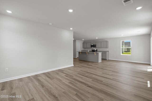 6986 Seaside Palms Pl SW, Sunset Beach, NC 28468 - unfurnished living room with recessed lighting and light wood finished floors