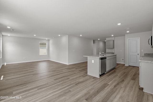 6986 Seaside Palms Pl SW, Sunset Beach, NC 28468 - kitchen featuring appliances with stainless steel finishes, recessed lighting, open floor plan, an island with sink, and light wood-style flooring