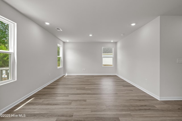 6986 Seaside Palms Pl SW, Sunset Beach, NC 28468 - empty room featuring healthy amount of natural light, recessed lighting, and wood finished floors