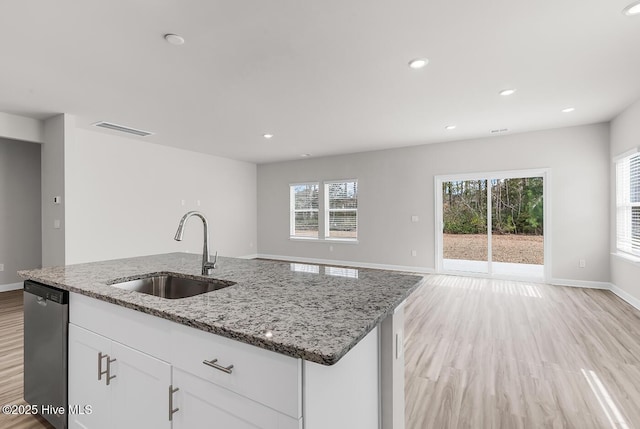 kitchen with sink, white cabinetry, light stone counters, an island with sink, and stainless steel dishwasher