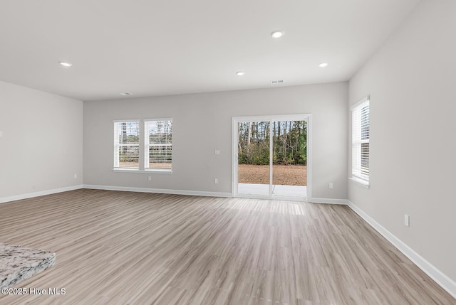 unfurnished room featuring a wealth of natural light and light hardwood / wood-style floors